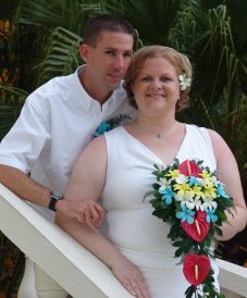 curved bride holding her bouquet with her groom at the back