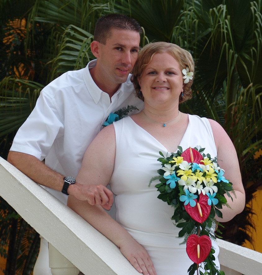 curved bride holding her bouquet with her groom at the back