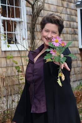 woman smiling and holding a flower finding the one online