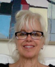 A blonde woman wearing eyeglasses taking a selfie