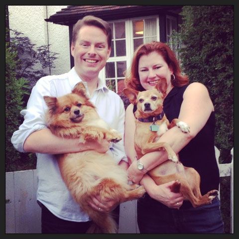 happy couple holding their 2 dogs