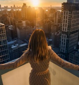 a woman on rooftop enjoying the view of beautiful sunset