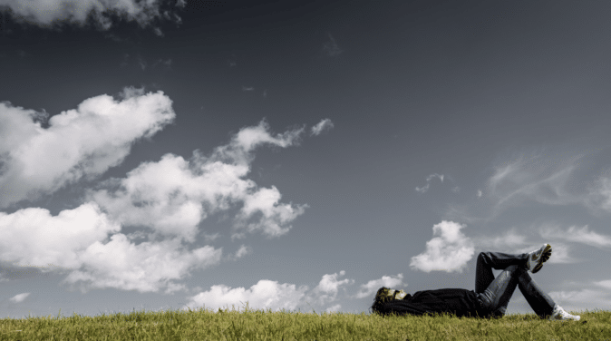 Man laying in a field having a dream